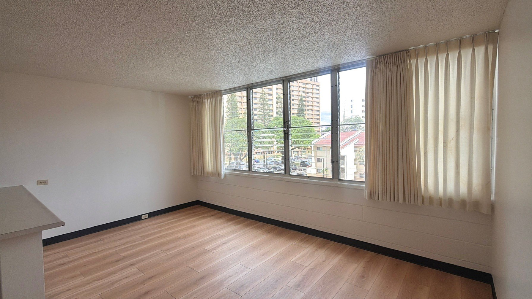 A room with a window and wooden flooring.